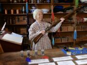 Fort Vancouver National Historical Site volunteer Rosanne Petersen holds up a musket in the trading post room on Saturday during a Women’s History Month event. Petersen showed visitors what items people could trade in or trade for at the fort, including muskets, blankets and girls of marriageable age.