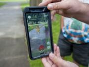 Tyler Disney of Ridgefield shows how the interactive app works Tuesday morning, July 12, 2016 at Esther Short Park.