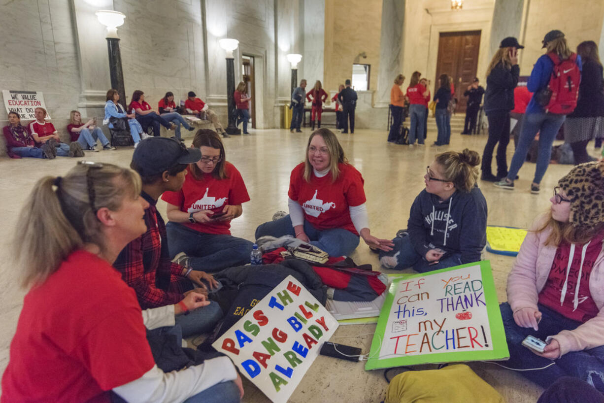 From left, kindergarten teacher Terra Triggs, first grade teacher Andrea Mason, kindergarten teacher Lisa Taylor, reading specialist Shelly Sexton, Brynn Triggs, Nikki Sexton relax and talk as they wait for the latest legislative news at the capitol in Charleston, W.V., on Monday, March 5, 2018; the eighth day of statewide school closures. All are teachers at Hedgesville Elementary school in Berkeley Country, W.V.