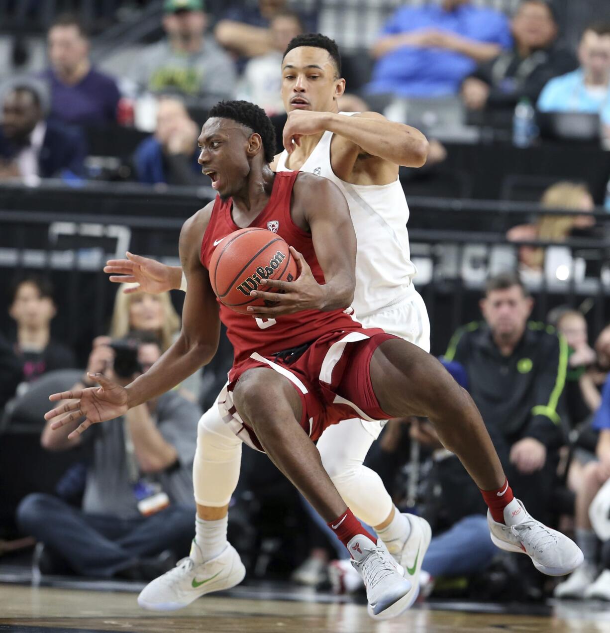 Washington State's Robert Franks, left, tries to pass as he falls to the court as Oregon's Elijah Brown defends during the first half of an NCAA college basketball game in the first round of the Pac-12 men's tournament Wednesday, March 7, 2018, in Las Vegas.