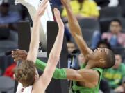 Oregon's Kenny Wooten, right, shoots while covered by Utah's Jayce Johnson during the second half of an NCAA college basketball game in the quarterfinals of the Pac-12 men's tournament Thursday, March 8, 2018, in Las Vegas. Oregon won 68-66.