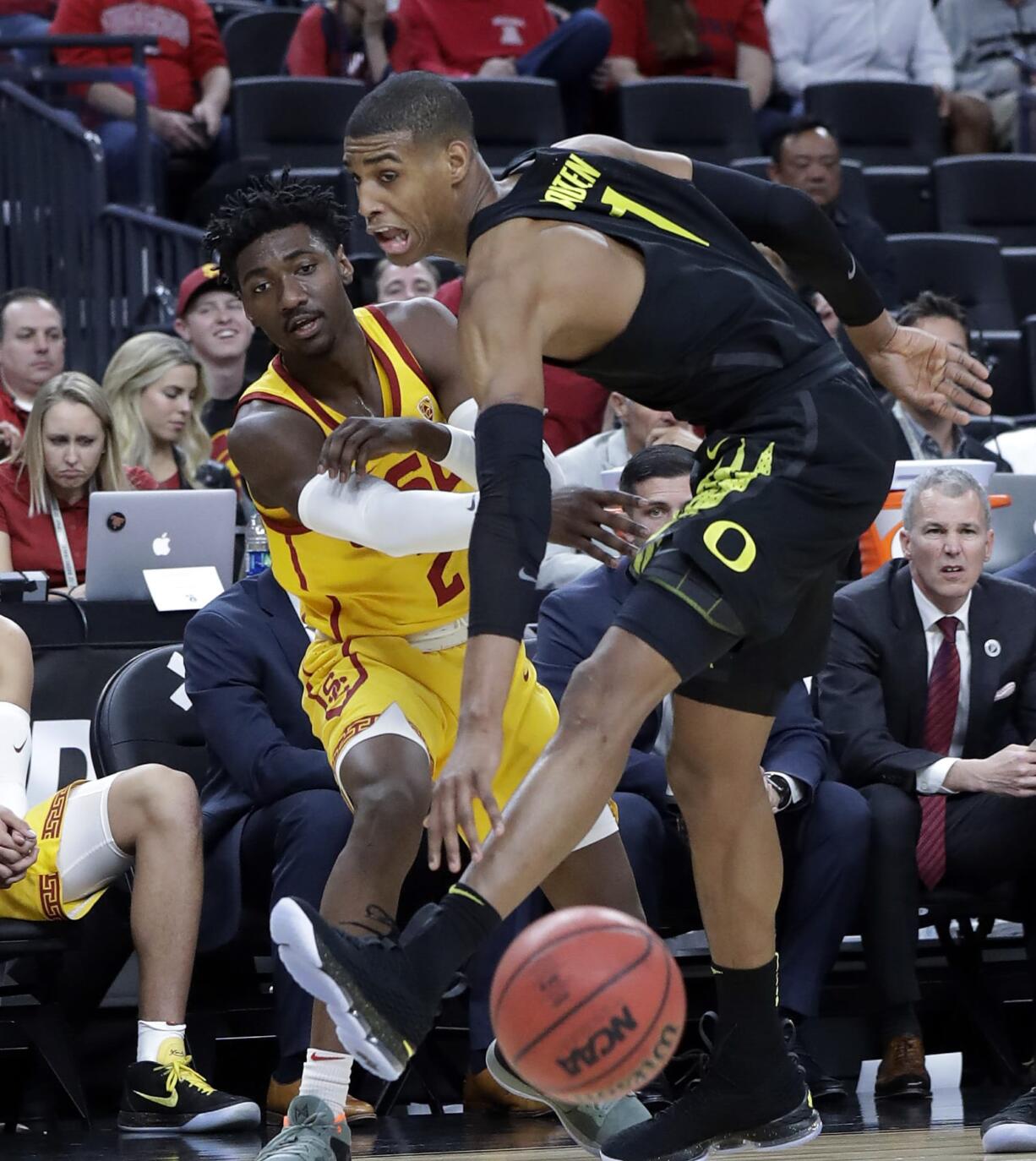 Southern California's Jonah Mathews, left, passes the ball around Oregon's Kenny Wooten during the first half of an NCAA college basketball game in the semifinals of the Pac-12 men's tournament Friday, March 9, 2018, in Las Vegas.