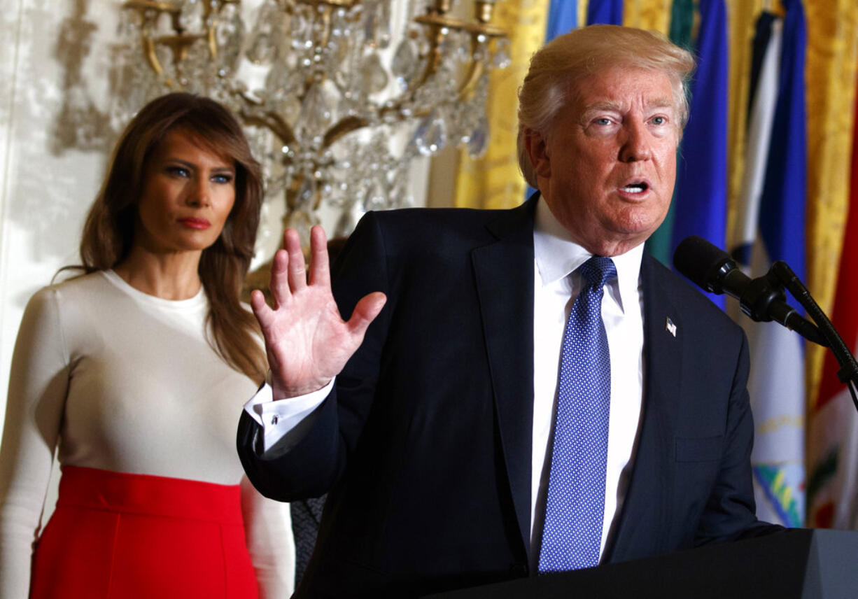 FILE - In this Friday, Oct. 6, 2017, file photo, President Donald Trump speaks during an event at the White House in Washington, as first lady Melania Trump listens. Trump's plan to combat opioid drug addiction calls for stiffer penalties for drug traffickers, including the death penalty where it's appropriate under current law. The president is scheduled to unveil his plan Monday, March 19, 2018, in New Hampshire, a state hard-hit by the crisis. He'll be accompanied by first lady Melania Trump, who has shown an interest in the issue, particularly as it pertains to children.