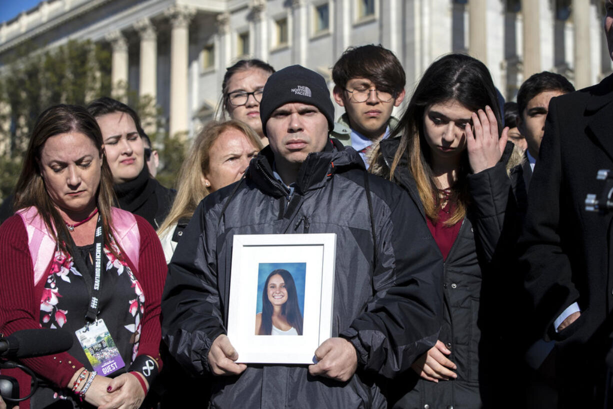 Ilan Alhadeff, joined at left by his wife Lori Alhadeff, holds a photograph of their daughter, Alyssa Alhadeff, 14, who was killed at Marjory Stoneman Douglas High School in Parkland, Fla., during a rally by lawmakers and student activists in support of gun control at the U.S. Capitol in Washington, Friday, March 23, 2018, a day before the March for Our Lives event. (AP Photo/J.