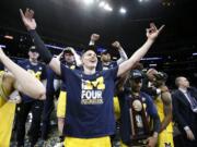 Michigan forward Moritz Wagner, foreground, and teammates celebrate after defeating Florida State 58-54 in an NCAA men's college basketball tournament regional final Saturday, March 24, 2018, in Los Angeles.