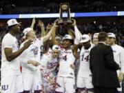 Kansas' Devonte' Graham (4) holds the trophy after defeating Duke in a regional final game in the NCAA men's college basketball tournament Sunday, March 25, 2018, in Omaha, Neb. Kansas won 85-81 in overtime.