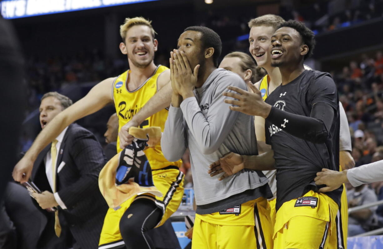 UMBC players celebrate a teammate’s basket against Virginia during the second half of a first-round game in the NCAA men’s college basketball tournament in Charlotte, N.C., Friday, March 16, 2018.