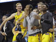 UMBC players celebrate a teammate’s basket against Virginia during the second half of a first-round game in the NCAA men’s college basketball tournament in Charlotte, N.C., Friday, March 16, 2018.