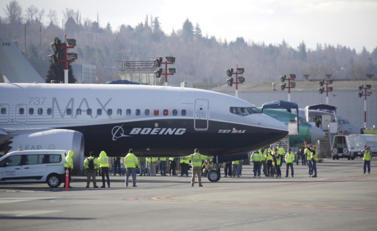 Employees look on as a Boeing 737 MAX 7 pulls away to taxi for the airplane’s first, Friday, March 16, 2018, in Renton, Wash.