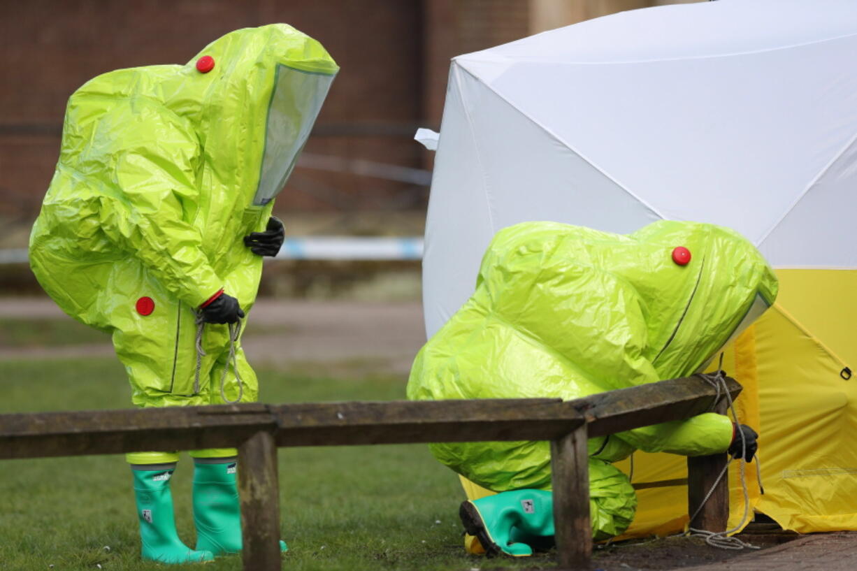 Personnel in hazmat suits work to secure a tent covering a bench in the Maltings shopping centre in Salisbury, England on Thursday March 8, 2018, where former Russian double agent Sergei Skripal and his daughter Yulia were found critically ill by exposure to a nerve agent on Sunday.