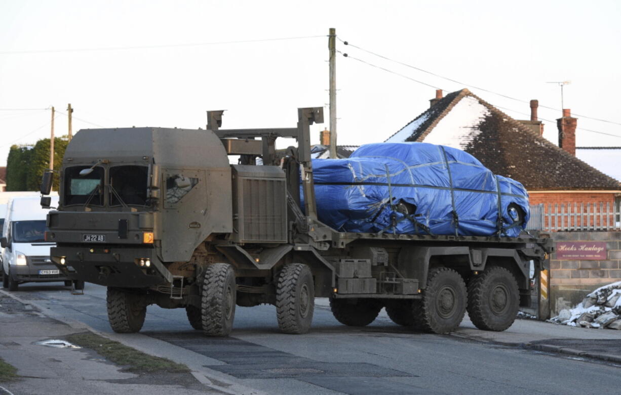 A vehicle wrapped in blue tarpaulin is removed from Larkhill Road in Durrington, 10 miles (16 kilometers) north of Salisbury, England, on the back of an Army lorry Monday as the investigation into the suspected nerve agent attack on Russian double agent Sergei Skripal and his daughter Yulia continues. A road in the village of Durrington was closed off and tents were erected as the military and police searched for clues Monday.