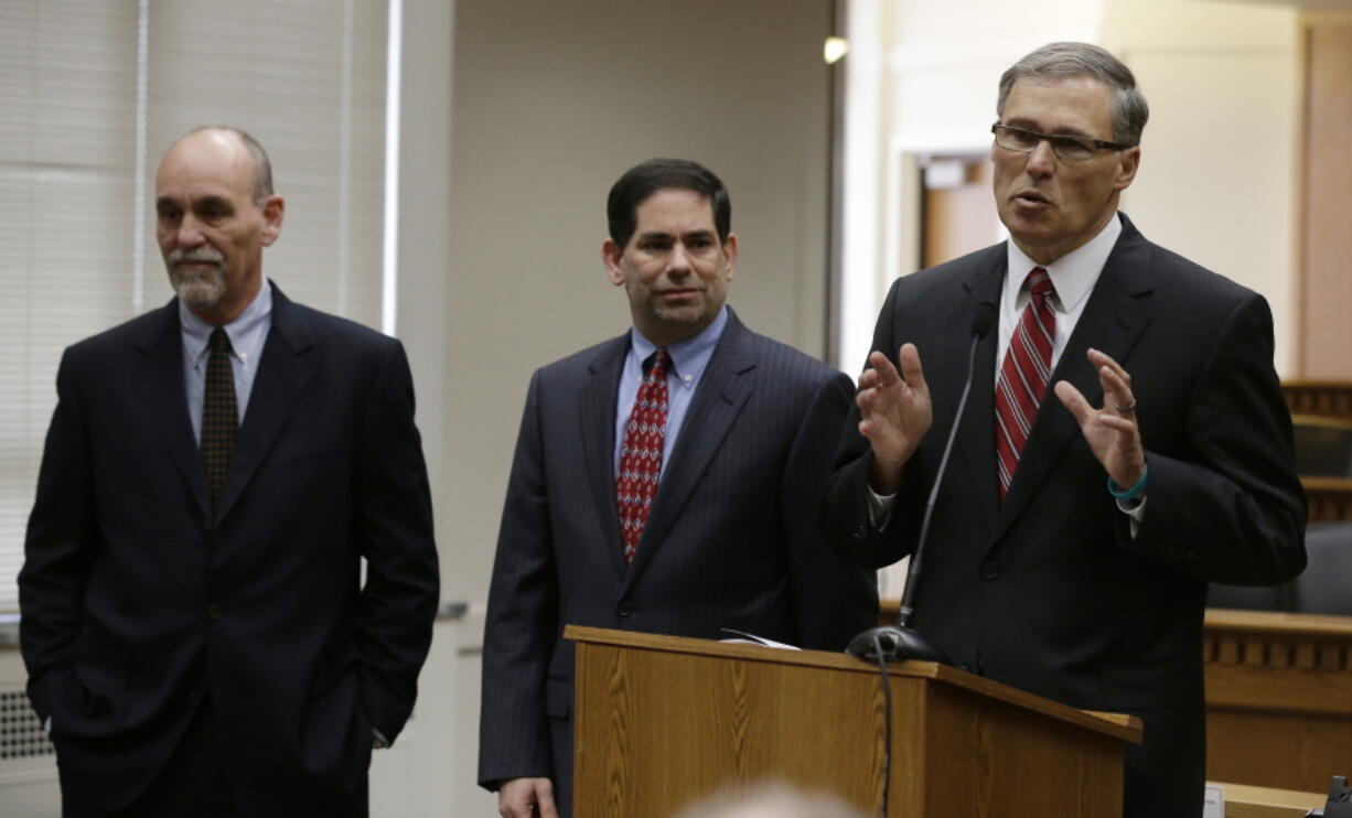 FILE - In this Jan. 10, 2013, file photo, Washington Governor-elect Jay Inslee, right, stands with two newly announced members of his cabinet during the annual AP Legislative Preview at the Capitol in Olympia, Wash. At left is Dale Peinecke, who will head the Employment Security Department, and center is Joel Sacks, who will lead the Department of Labor & Industries. Peinecke, the head of Washington state’s Employment Security Department, has resigned on Monday, March 12, 2018, in a letter sent to Gov. Inslee, after an outside investigation found several employees complained about him putting his arms around them or looking at their bodies in ways that made them uncomfortable. (AP Photo/Ted S.