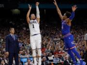 Villanova’s Jalen Brunson (1) shoots a 3-point basket against Kansas’s Devonte’ Graham (4) during the second half in the semifinals of the Final Four NCAA college basketball tournament, Saturday, March 31, 2018, in San Antonio. (AP Photo/David J.