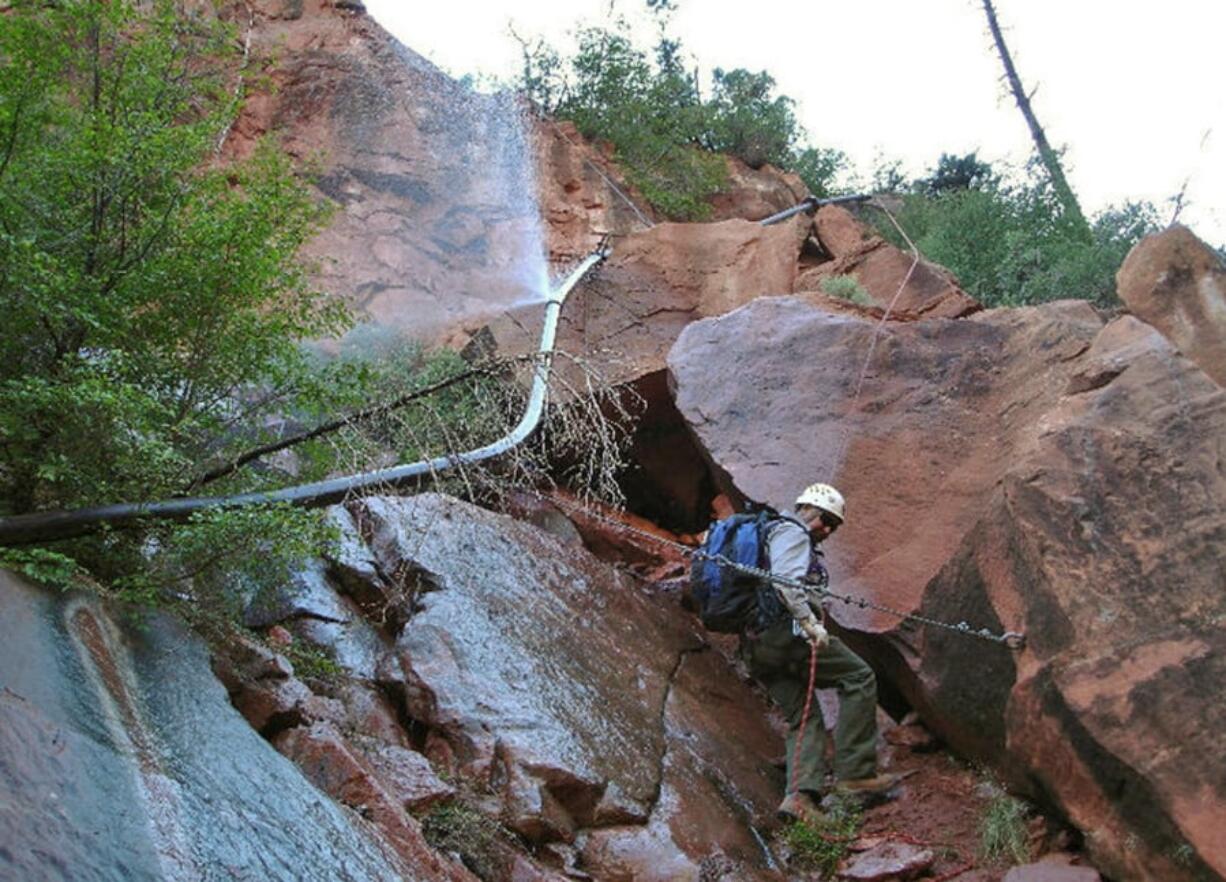 Water sprays from a break in an exposed section of the Grand Canyon trans-canyon waterline as a worker attempts repairs. Crews are drilling at the bottom of the Grand Canyon to test the idea of shifting the area where water is drawn to serve millions of people at the park’s popular South Rim.