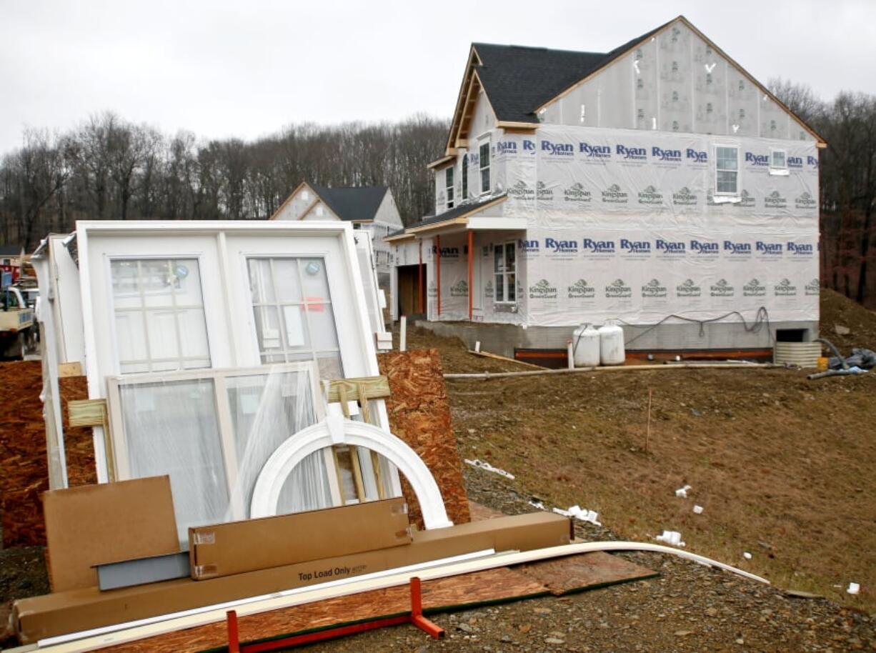 Building materials are stacked along home sites as construction is underway Feb. 16 at a new housing plan in Zelienople, Pa. The Commerce Department reported Friday that housing starts fell 7 percent in February. A slowdown in in multifamily construction caused the drop. Single-family homes were up.