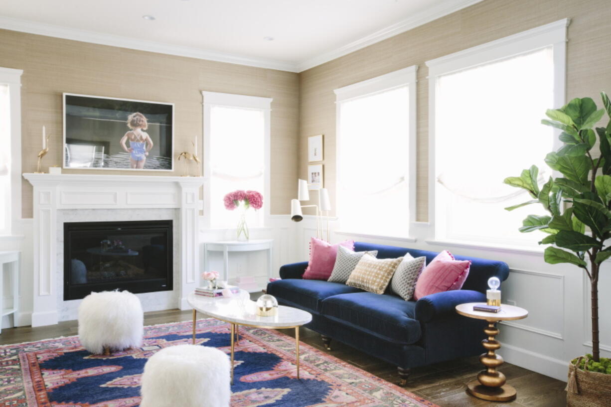 In this living room designed by interior designer McClendon the richness of a royal blue sofa and gold-toned accessories is balanced by the softness of neutral walls.