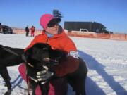 Handler Elin Bentsen poses with Hudson before the start of the Iditarod Trail Sled Dog Race in Anchorage, Alaska. Hudson bolted from his crate and was missing for about three hours Saturday during the ceremonial start in Anchorage. Musher Lars Monsen said he took the team to the last known spot where Hudson was seen Saturday, and Hudson either heard or smelled his pack and came back.