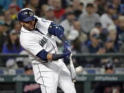 Seattle Mariners' Nelson Cruz connects for a two-run home run against the Cleveland Indians during the first inning of a baseball game Thursday, March 29, 2018, in Seattle.