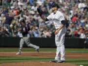 Seattle Mariners starting pitcher James Paxton, right, stands on the mound as Cleveland Indians' Yonder Alonso, left, rounds the bases after Alonso hit a grand slam during the first inning of a baseball game, Saturday, March 31, 2018, in Seattle. (AP Photo/Ted S.