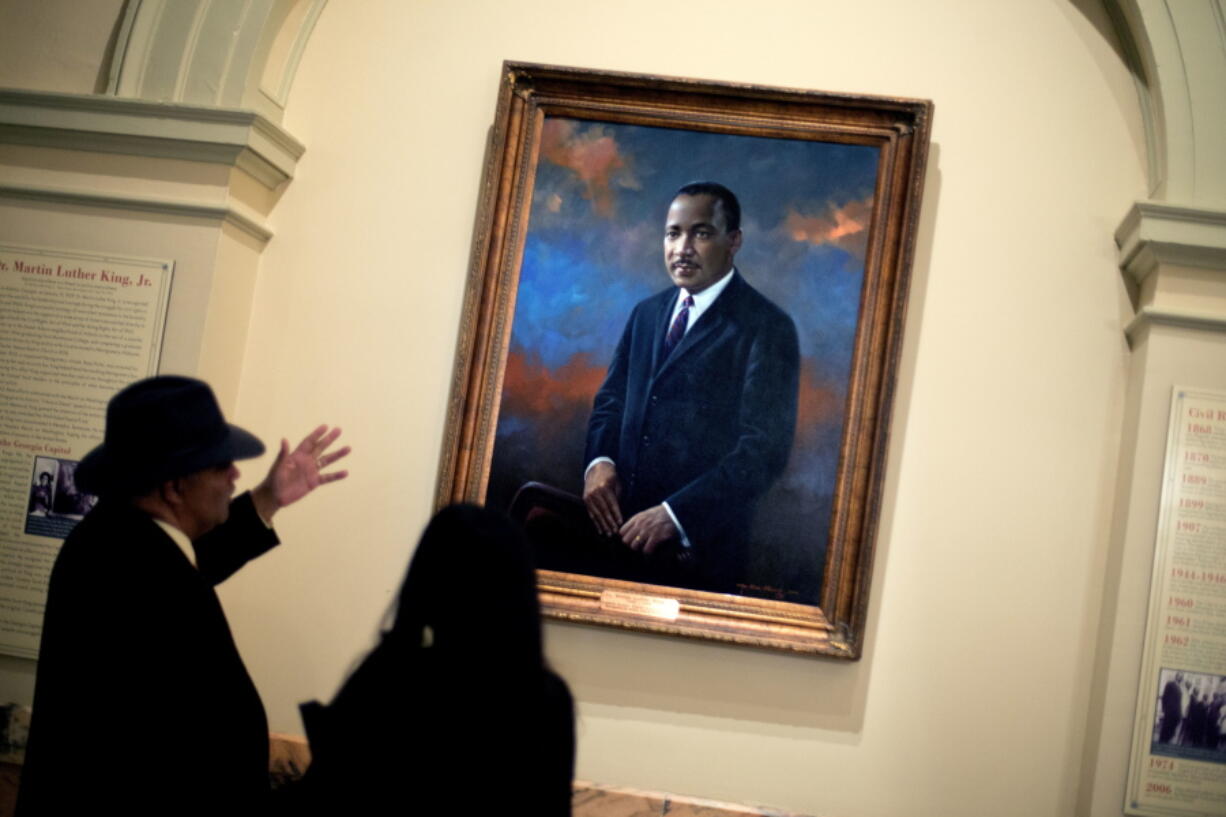 People look at the portrait of the Rev. Dr. Martin Luther King Jr. following a service celebrating King’s birthday inside the Georgia State Capitol in Atlanta. Fifty years after King’s assassination, only 1 in 10 African Americans think the United States has achieved all or most of the goals of the civil rights movement he led, according to a new poll by the Associated Press-NORC Center for Public Affairs Research.