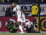 Los Angeles Galaxy forward Ola Kamara, center, celebrates his goal as Portland Timbers defender Larrys Mabiala, left, and goalkeeper Jake Gleeson lie on the ground during the first half of a Major League Soccer game, Sunday, March 4, 2018, in Carson, Calif. (AP Photo/Mark J.