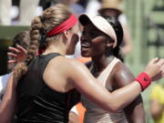 Jelena Ostapenko, left, of Latvia, hugs Sloane Stephens at the net after the final at the Miami Open tennis tournament, Saturday, March 31, 2018, in Key Biscayne, Fla. Stephens won 7-6 (5), 6-1.