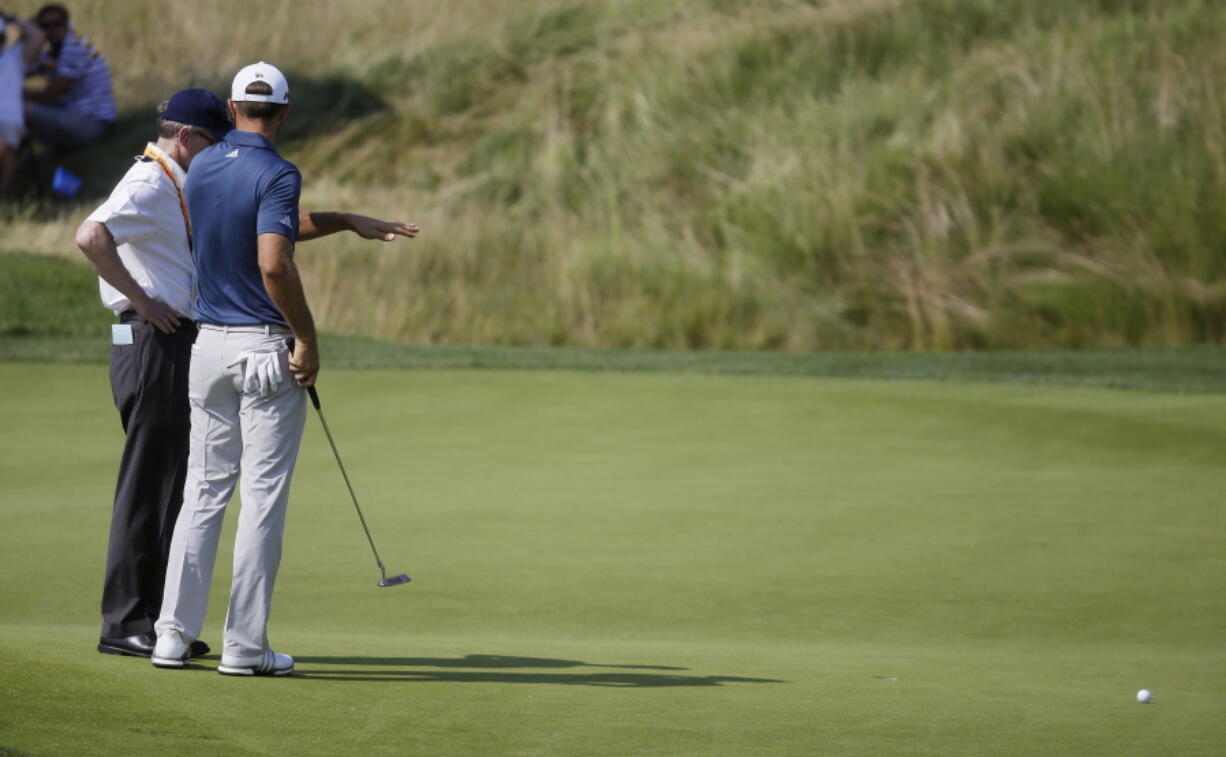 Dustin Johnson, right, talks to a rules official on the fifth green during the final round of the U.S. Open golf tournament on June 19, 2016, at Oakmont Country Club in Oakmont, Pa. The USGA and R&A introduced a modern set of rules effective in 2017 designed to make them easier to understand.