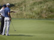 Dustin Johnson, right, talks to a rules official on the fifth green during the final round of the U.S. Open golf tournament on June 19, 2016, at Oakmont Country Club in Oakmont, Pa. The USGA and R&A introduced a modern set of rules effective in 2017 designed to make them easier to understand.