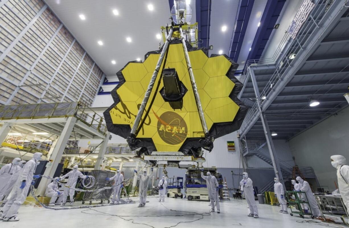 Technicians lift the mirror of the James Webb Space Telescope using a crane at the Goddard Space Flight Center in Greenbelt, Md. The telescope’s 18-segmented gold mirror is specially designed to capture infrared light from the first galaxies that formed in the early universe. On Tuesday, March 27, 2018, NASA announced it has delayed the launch of the next-generation space telescope until 2020.