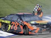 Martin Truex Jr. celebrates after winning the NASCAR 400 mile auto race Sunday, March 18, 2018, at Auto Club Speedway in Fontana, Calif .