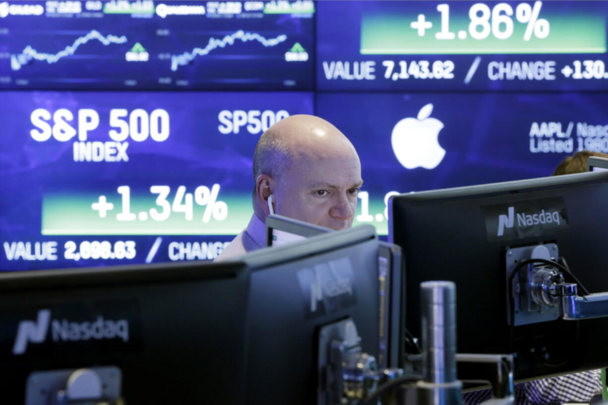 A Nasdaq employee works at his computer at the Nasdaq MarketSite, in New York. On Thursday, March 8, the Federal Reserve reports on household wealth for the October-December quarter.