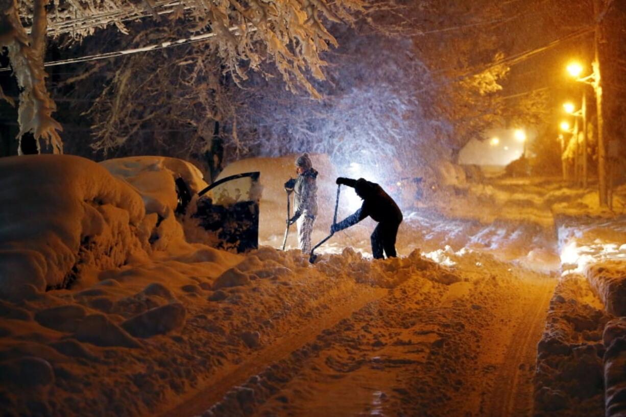 Residents of Mills Street in Morristown, N.J., dig out their car after a snowstorm dumped more than a foot of snow in the area Wednesday.