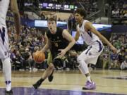 Oregon guard Payton Pritchard, center, drive past Washington guard Matisse Thybulle, right, during the second half of an NCAA college basketball game, Saturday, March 3, 2018, in Seattle. Oregon won 72-64. (AP Photo/Ted S.