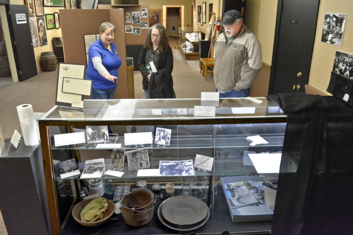 In a Thursday, March 22, 2018 photo, Baker Heritage Museum volunteer Mindi Sherrieb, left, chats with Stewart and Sonya Shipley of Chimacum, Wash., in Baker City, Ore., as she continues to arrange and present the displays of “Paint Your Wagon” memorabilia. The new exhibit at the Baker Heritage Museum celebrates the 50th anniversary of “Paint Your Wagon,” the big-budget Western musical that was filmed in Eastern Oregon. (S.