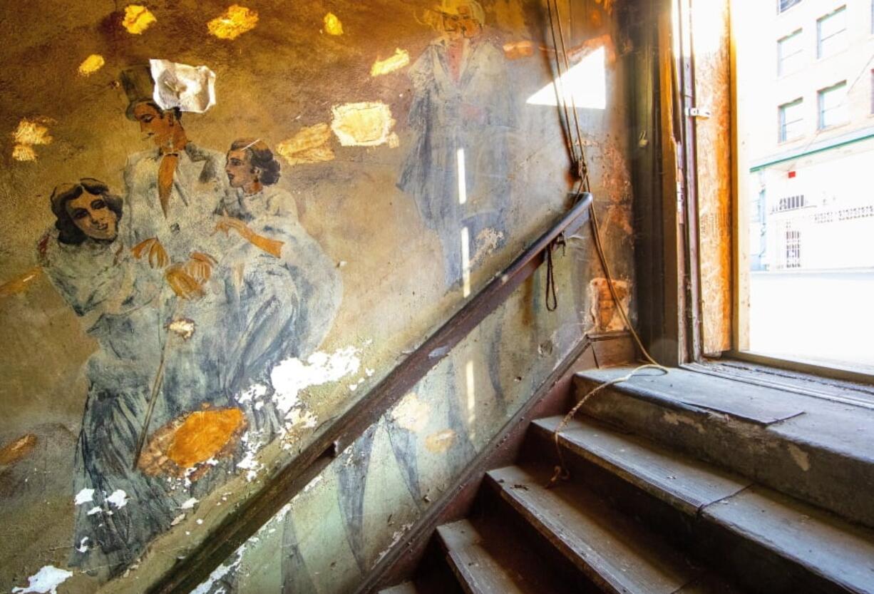 This March 20, 2018 photo shows Prohibition-era murals that were discovered during the renovation of the Louisa Hotel on South King Street in the International District of Seattle. The paintings depict patrons in formal dress heading down a steep staircase into the basement of the hotel. The building was once the Hudson Hotel and then the Louisa, where Chinese, Japanese and Filipino immigrants would stay before being shipped off to Alaska to work in fish canneries.