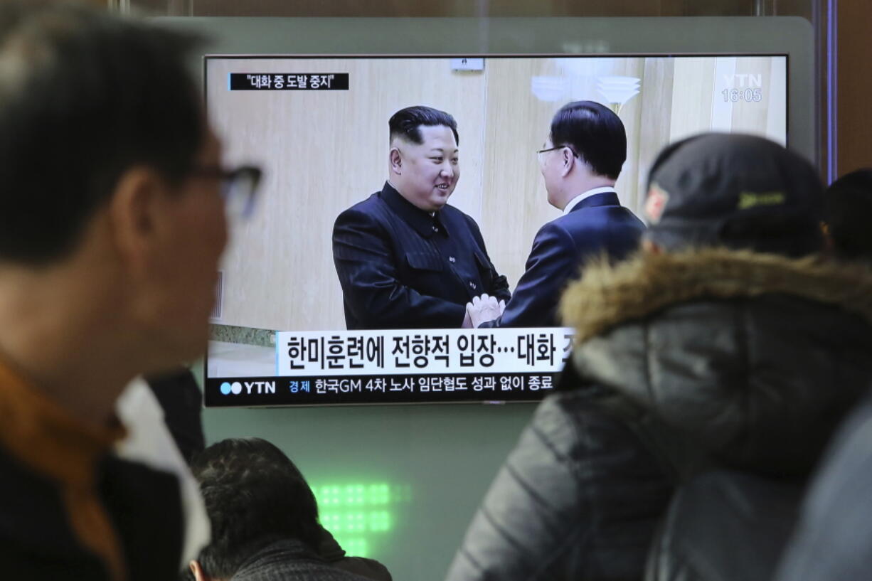 People watch a TV screen showing North Korean leader Kim Jong Un, left, meeting with South Korean National Security Director Chung Eui-yong in Pyongyang, North Korea, at the Seoul Railway Station in Seoul, South Korea, on Wednesday. After years of refusal, North Korean leader Kim Jong Un is willing to discuss the fate of his atomic arsenal with the United States and has expressed a readiness to suspend nuclear and missile tests during such talks, a senior South Korean official said Tuesday. Korean characters seen on the screen read: “South Korea-U.S.