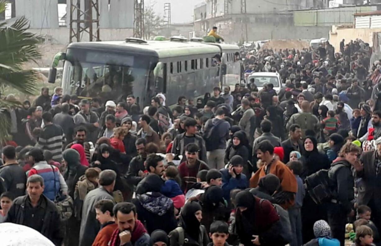 This photo released by the Syrian official news agency SANA, shows Syrian civilians with their belongings, fleeing from fighting between the Syrian government forces and rebels, in eastern Ghouta, a suburb of Damascus, Syria, Thursday, March. 15, 2018. Thousands of civilians streamed out of Hamouria in Syria’s besieged, opposition-held enclave of eastern Ghouta on Thursday, crossing on foot and in pick-up trucks and tractors to government-held territory near the capital, Damascus, according to footage on state-run Syrian television.