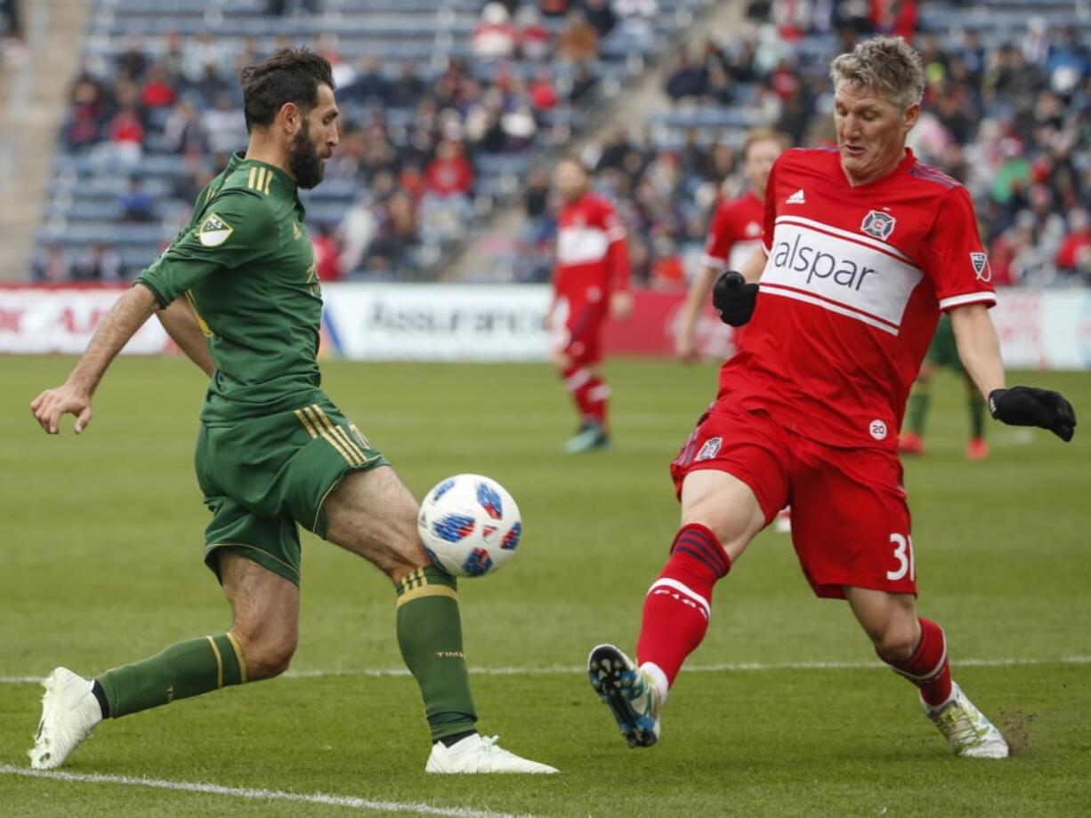 Portland Timbers midfielder Diego Valeri, left, battles for the ball with Chicago Fire midfielder Bastian Schweinsteiger, right, during the first half of an MLS soccer match, Saturday, March 31, 2018, in Bridgeview, Ill.