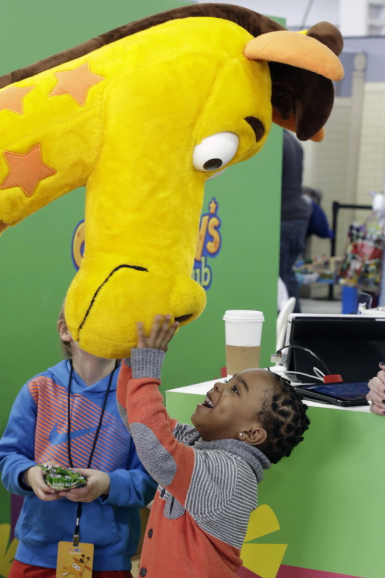 Jahmae Evans, 4, talks to Geoffrey the Giraffe — the corporate symbol for Toys R Us since 1965 — at the 2016 Toy Fair in New York.