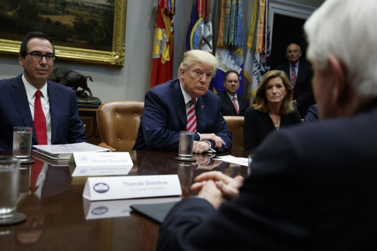 FILE- In this Oct. 31, 2017, file photo, Tom Donohue, President and CEO, U.S. Chamber of Commerce, foreground, speaks as Treasury Secretary Steve Mnuchin, left, President Donald Trump, second from left, and Karen Kerrigan, President and CEO, Small Business & Entrepreneurship Council, listen during a meeting in Washington. The U.S. Chamber of Commerce is warning Trump against slapping big tariffs on Chinese imports. “Simply put, tariffs are damaging taxes on American consumers,’’ Donohue said in a statement.