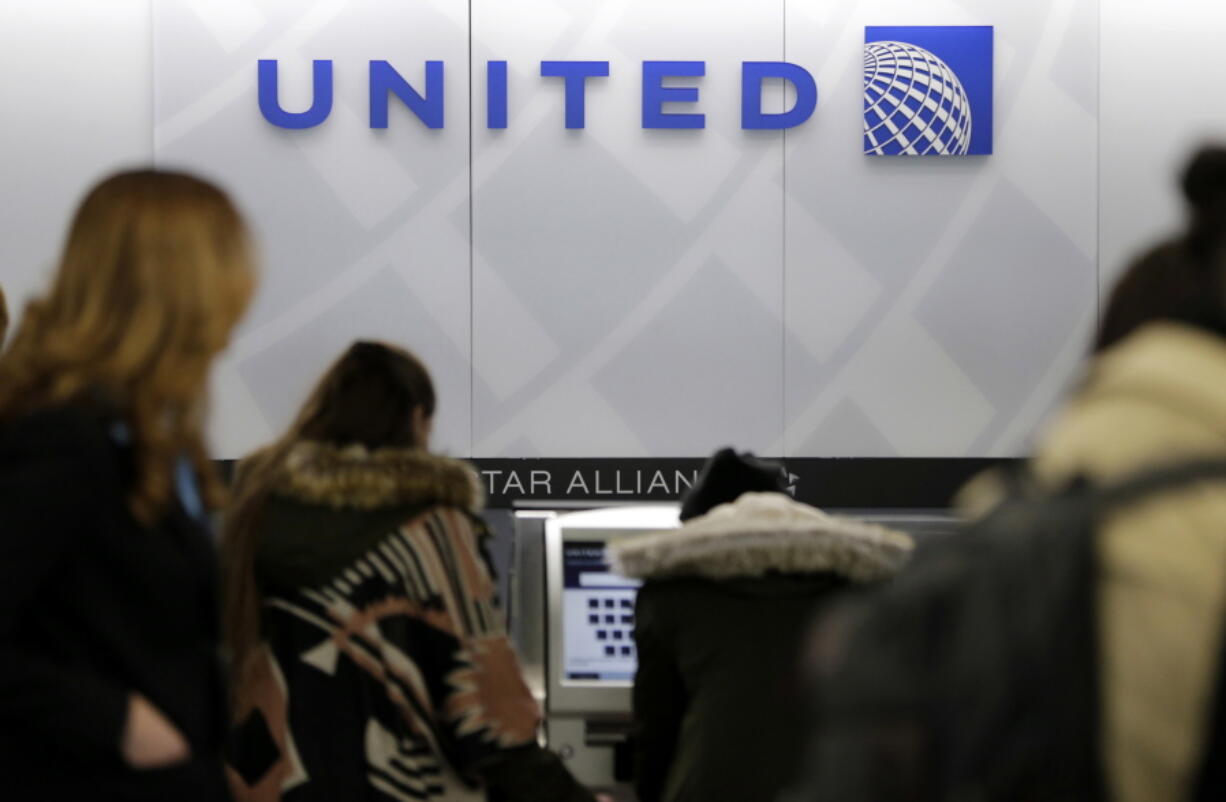 People stand in line at a United Airlines counter at LaGuardia Airport in New York. A dog died on a United Airlines plane after a flight attendant ordered its owner to put the animal in the plane’s overhead bin. United said Tuesday, March 13, 2018, that it took full responsibility for the incident on the Monday night flight from Houston to New York.