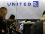 People stand in line at a United Airlines counter at LaGuardia Airport in New York. A dog died on a United Airlines plane after a flight attendant ordered its owner to put the animal in the plane’s overhead bin. United said Tuesday, March 13, 2018, that it took full responsibility for the incident on the Monday night flight from Houston to New York.