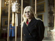 Donatella Versace poses next to one of the Tiara (1877) of pope Pius IX in Rome, Monday, Feb. 26, 2018. The Vatican is loaning some of its most beautiful liturgical vestments, jeweled miter caps and historic papal tiaras for an upcoming exhibit on Catholic influences in fashion at the Metropolitan Museum of Art. The Vatican culture minister, Cardinal Gianfranco Ravasi, joined Vogue Editor-in-Chief Anna Wintour and designer Donatella Versace in Rome on Monday to display a few of the Vatican treasures at the Palazzo Colonna, a onetime papal residence. “Heavenly Bodies: Fashion and the Catholic Imagination” is set to open May 10 at the Met’s Costume Institute in New York.