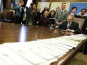 A long line of bills are placed on a table in the Governor’s conference room at the Capitol in Olympia on Wednesday. Ted S.