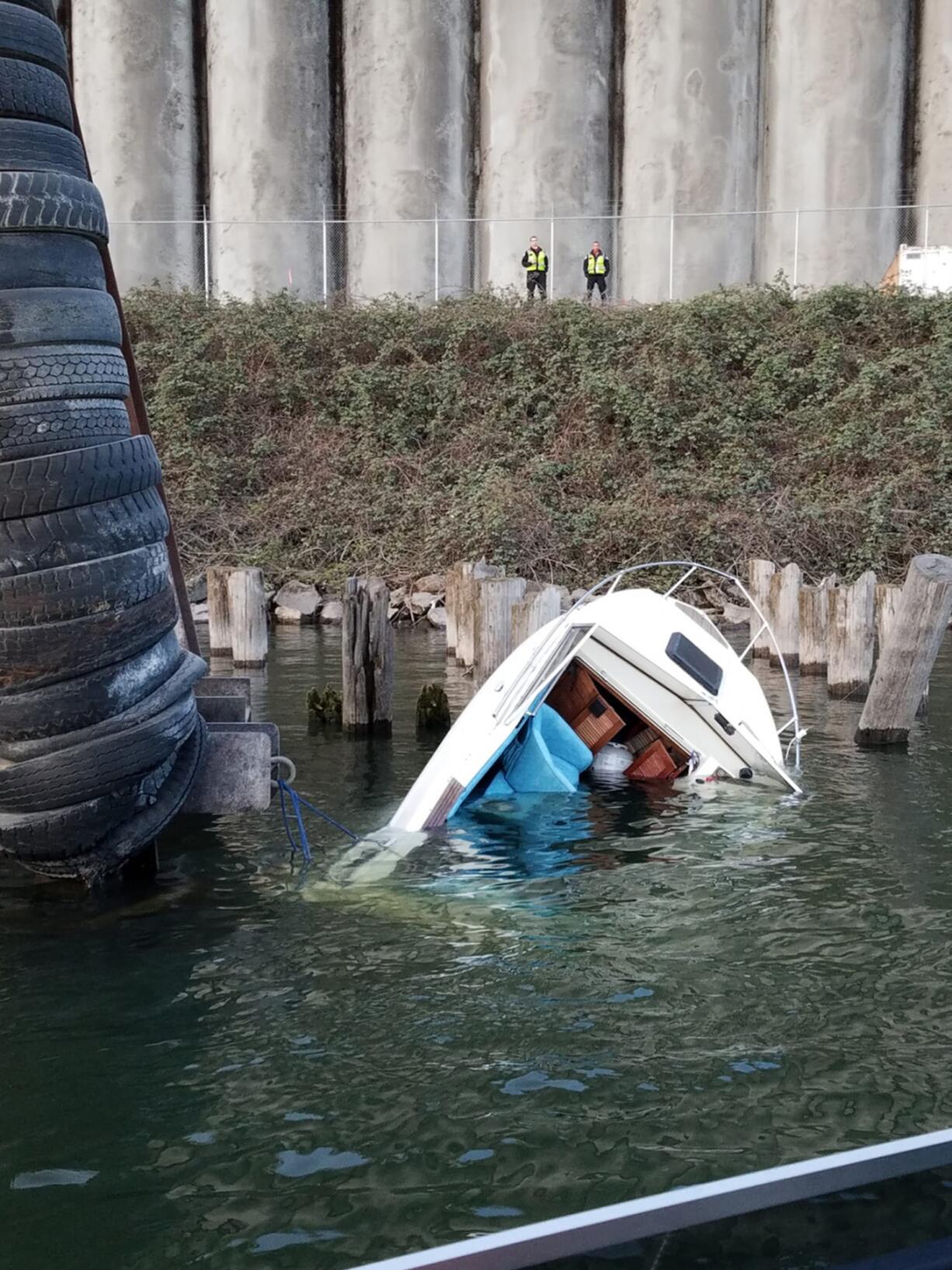 A boat sits tied to a piling on the Vancouver side of the Columbia River after a Coast Guard Station Portland boat crew aboard a 29-foot Response Boat - Small II, rescued three people from the boat on Saturday. (U.S.