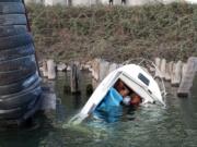 A boat sits tied to a piling on the Vancouver side of the Columbia River after a Coast Guard Station Portland boat crew aboard a 29-foot Response Boat - Small II, rescued three people from the boat on Saturday. (U.S.