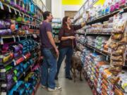 An employee assists a customer with dog food at a Petco store in Clark, N.J., in 2015.