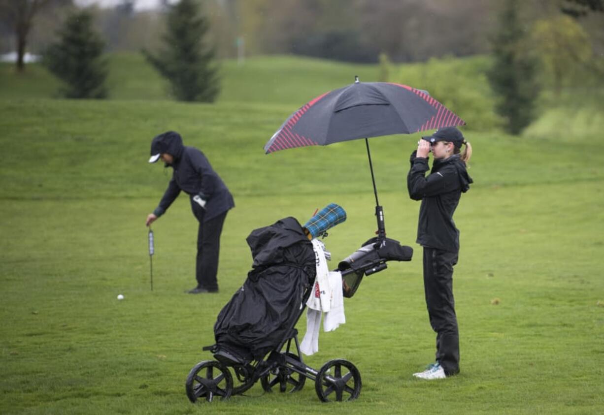 Camas' Hailey Oster uses a rangefinder to spot the green during the Chieftain Invitational at Tri-Mountain Golf Course in Ridgefield on Thursday April 12, 2018.