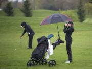 Camas' Hailey Oster uses a rangefinder to spot the green during the Chieftain Invitational at Tri-Mountain Golf Course in Ridgefield on Thursday April 12, 2018.