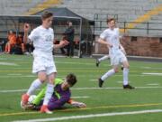 Battle Ground goalkeeper Nate Leu smothers the ball in front of Skyview’s Michael Kimbrell on Friday at Kiggins Bowl. Skyview scored three goals in the final five minutes to win 3-1.